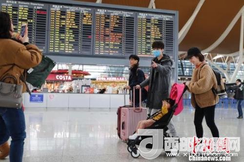 旅客帶著孩子前往辦票柜臺(tái)辦理登機(jī)手續(xù)?！∫罅⑶?攝