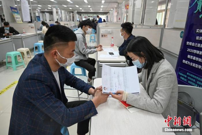 4月14日，招聘者在查看求職者簡歷。<a target='_blank'  data-cke-saved- >中新社</a>記者 王剛 攝