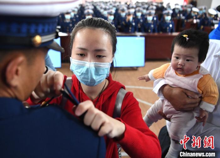 新消防員楊振的妻子彭莉與女兒現(xiàn)場(chǎng)見(jiàn)證丈夫加入“火焰藍(lán)”的神圣時(shí)刻?！⒅铱?攝