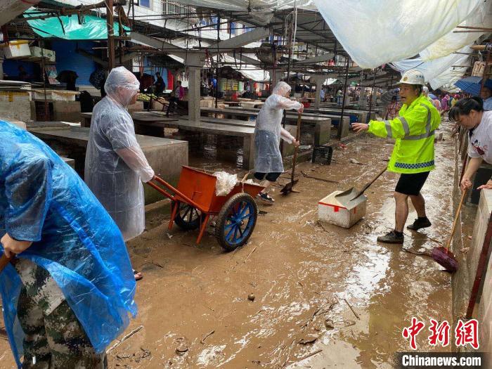 圖為7月26日，暴雨引發(fā)的洪水過境后，重慶萬州區(qū)分水鎮(zhèn)政府干部職工及志愿者清掃淤泥和垃圾?！　≈貞c萬州區(qū)委宣傳部供圖 攝