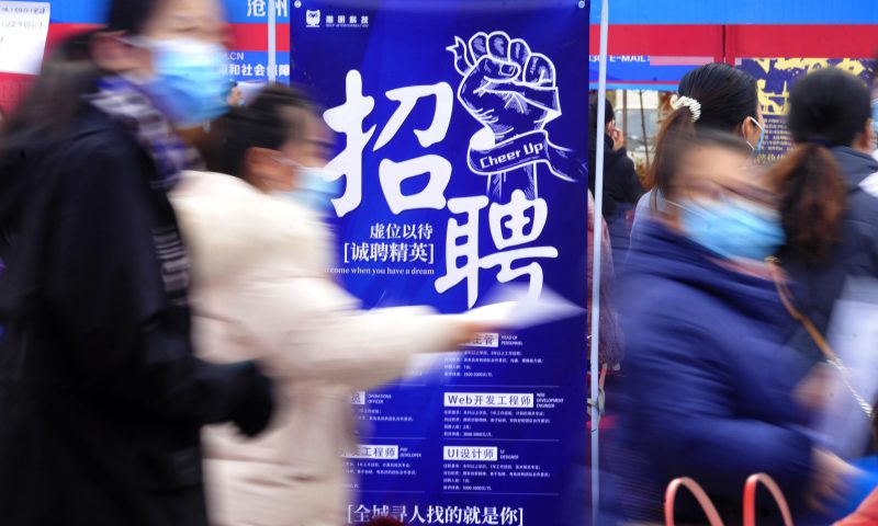 求職者從一家招聘企業(yè)的廣告牌前走過。新華社發(fā)（苑立偉 攝）